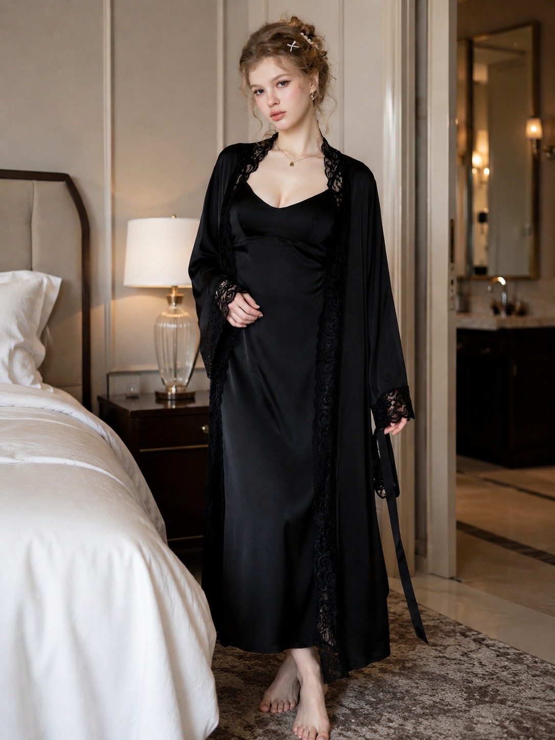 Model wearing Soft Noir black satin slip dress with lace robe in bedroom setting