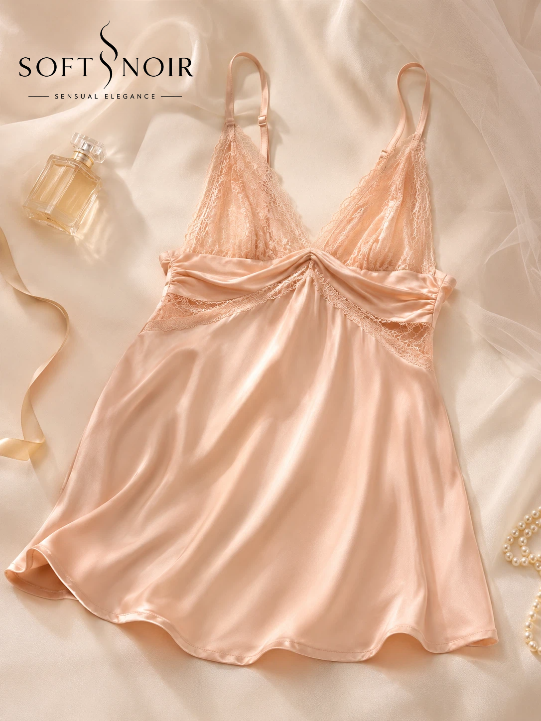 Champagne blush satin lace babydoll slip dress styled on cream silk fabric with elegant luxury details
