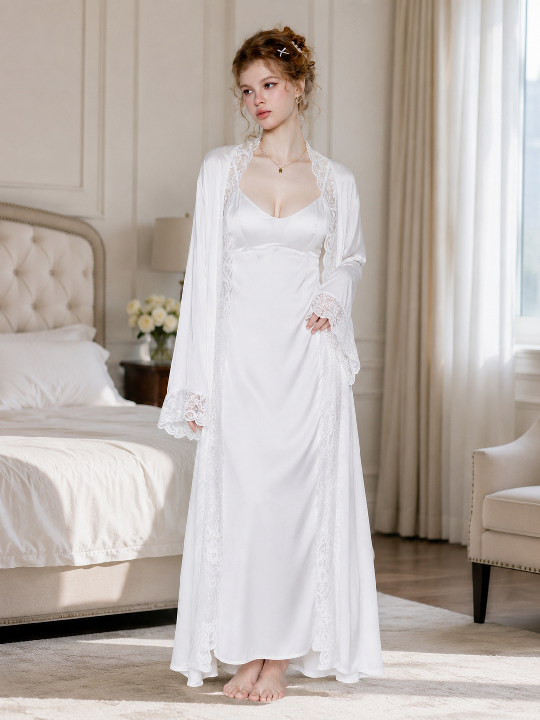 Model wearing Soft Noir pearl white satin slip dress with lace robe in bright bedroom