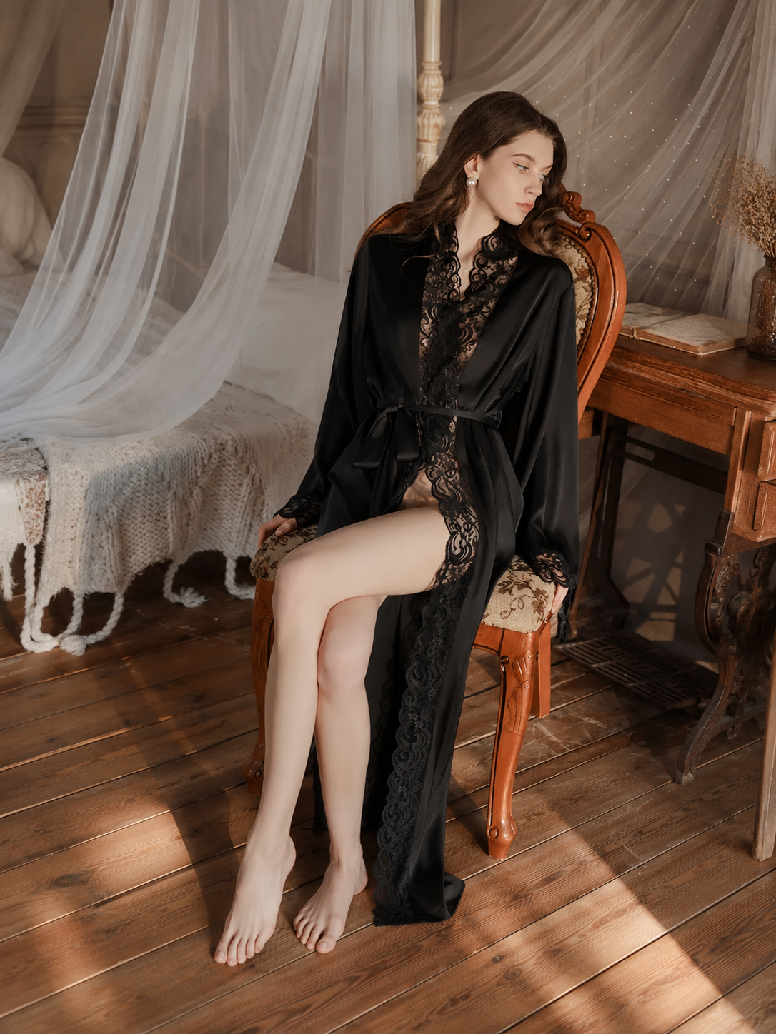Model wearing Soft Noir black satin lace long robe in vintage bedroom setting