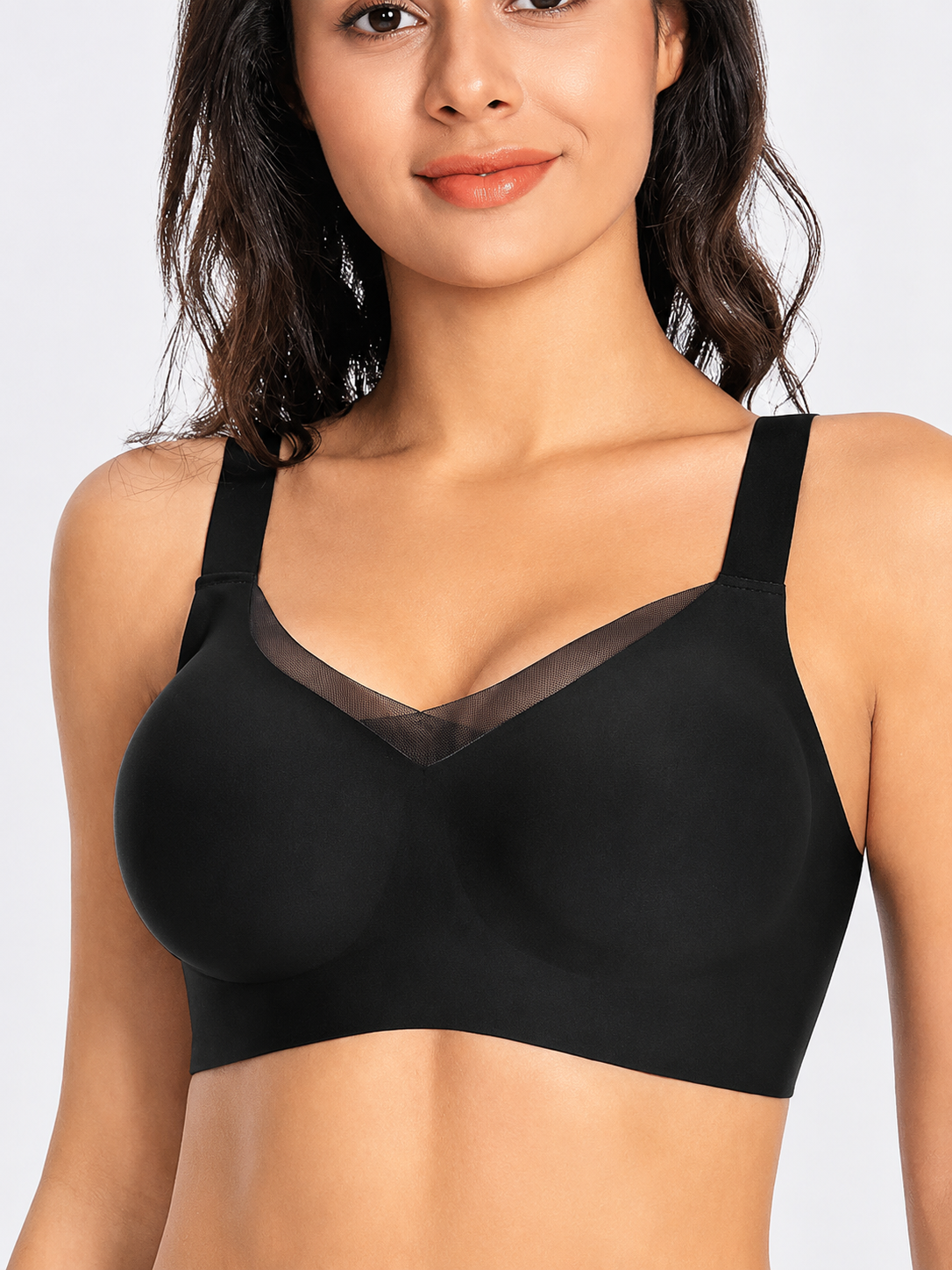 Model wearing Soft Noir black wireless seamless comfort bra with mesh V-neck detail