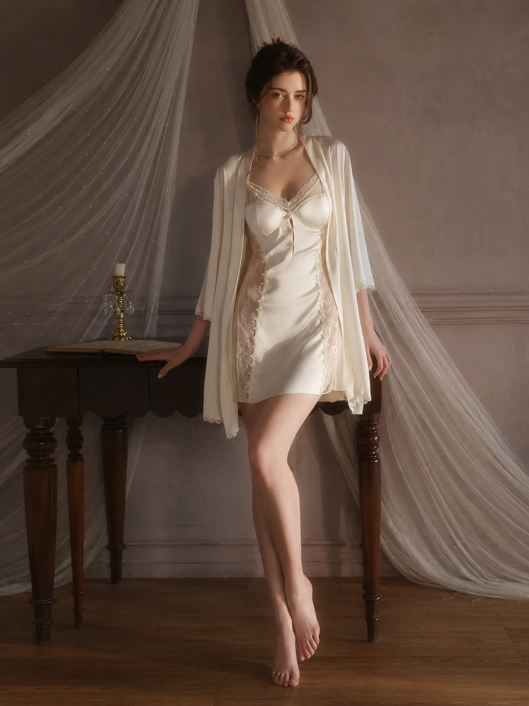 Model wearing Soft Noir ivory satin lace chemise and robe set in an elegant bedroom